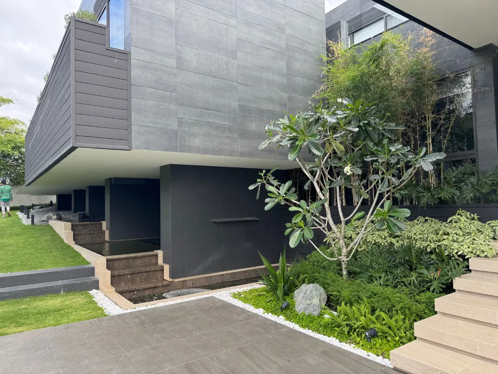 Reflecting pool and stone steps set beneath the cantilevered upper floor of a Montala Alviera residence